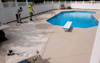 This image shows 2 men resurfacing a pool deck.