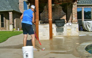 This image shows a man refinishing a pool deck.